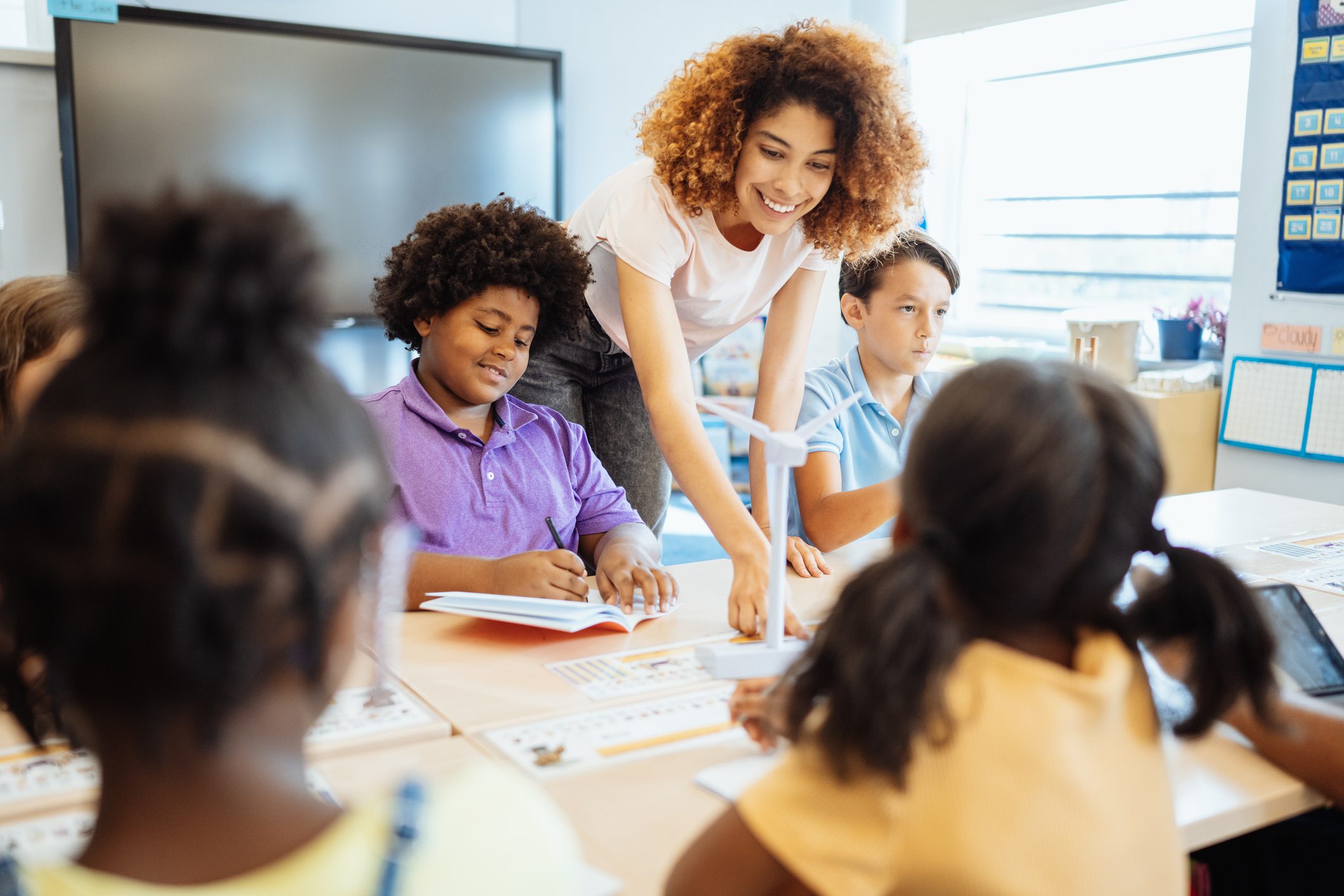 Diverse students learning together with teacher