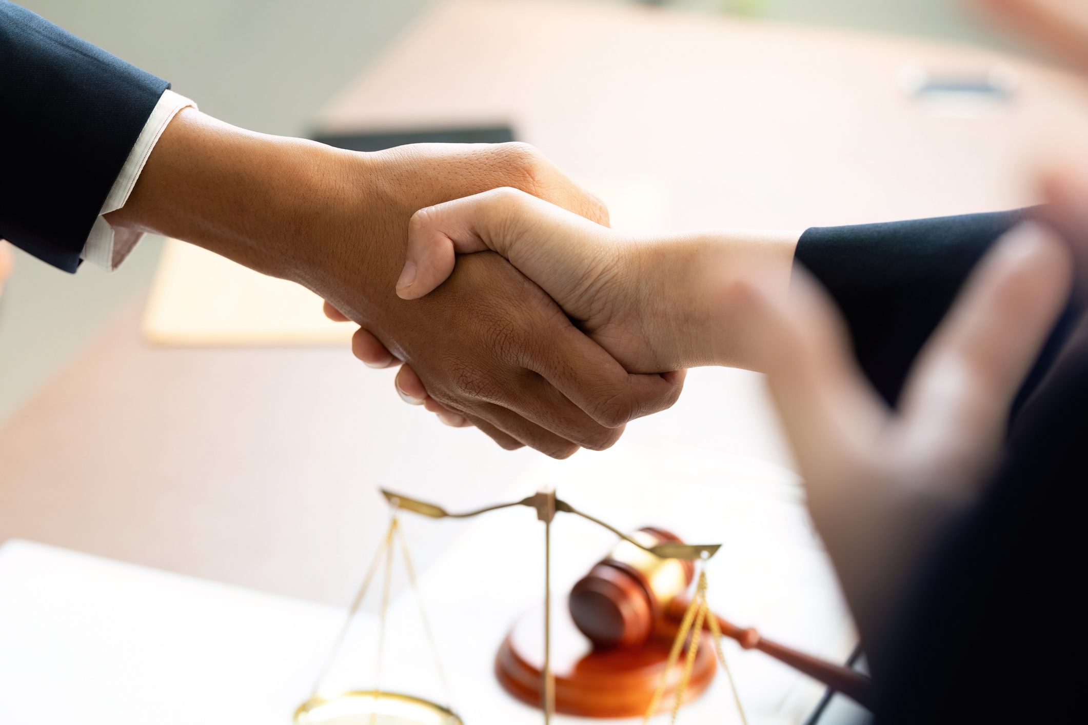 Handshake over legal documents and gavel