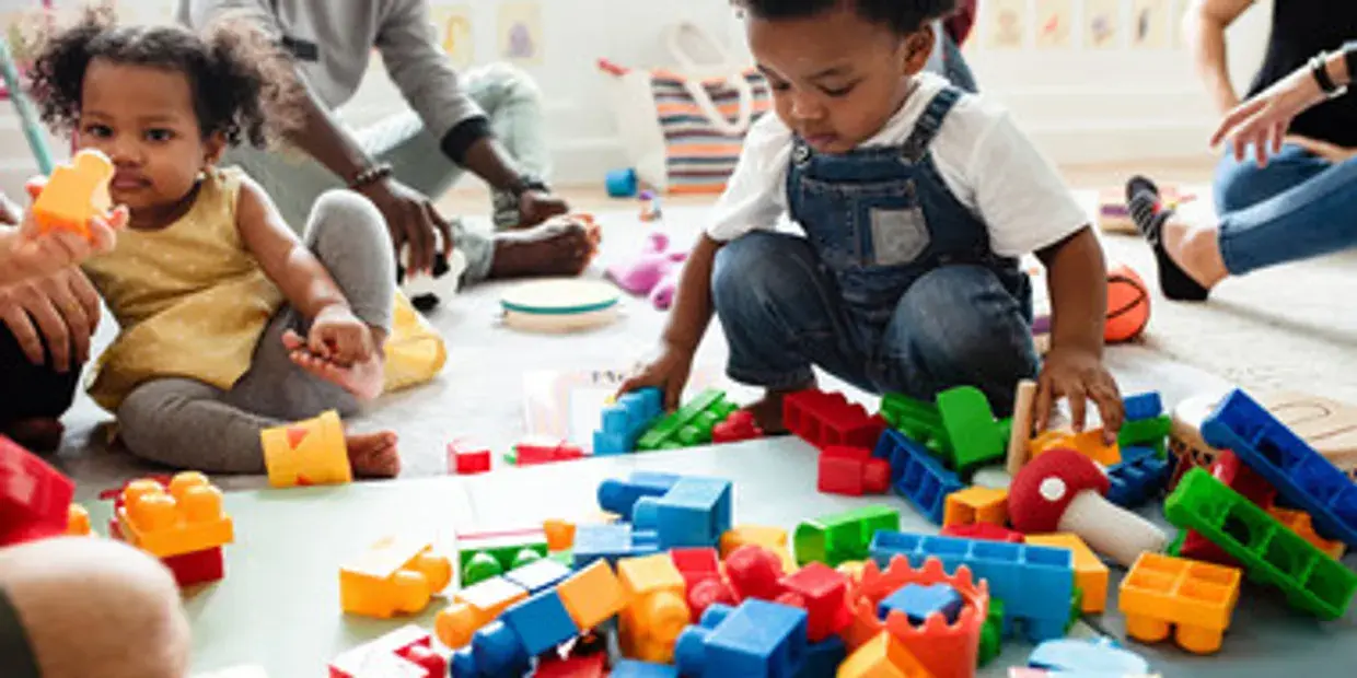 Toddlers playing with colorful building blocks