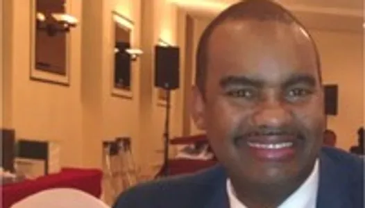 Smiling man in suit at indoor event