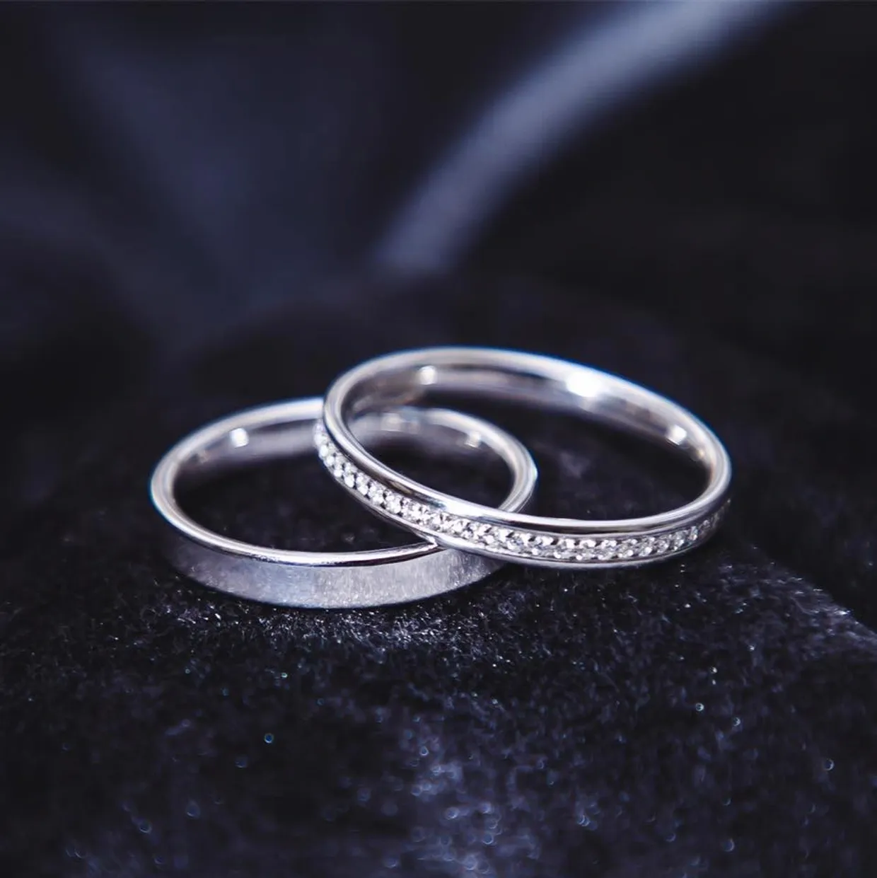 Two silver wedding rings on black velvet