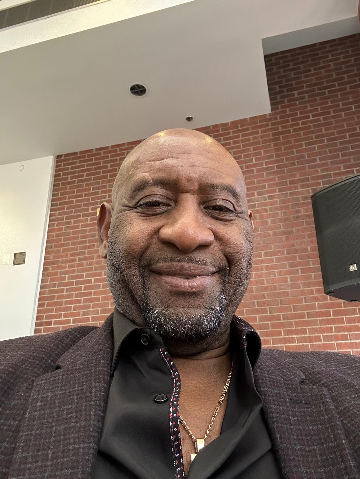 Smiling bald man in blazer indoors
