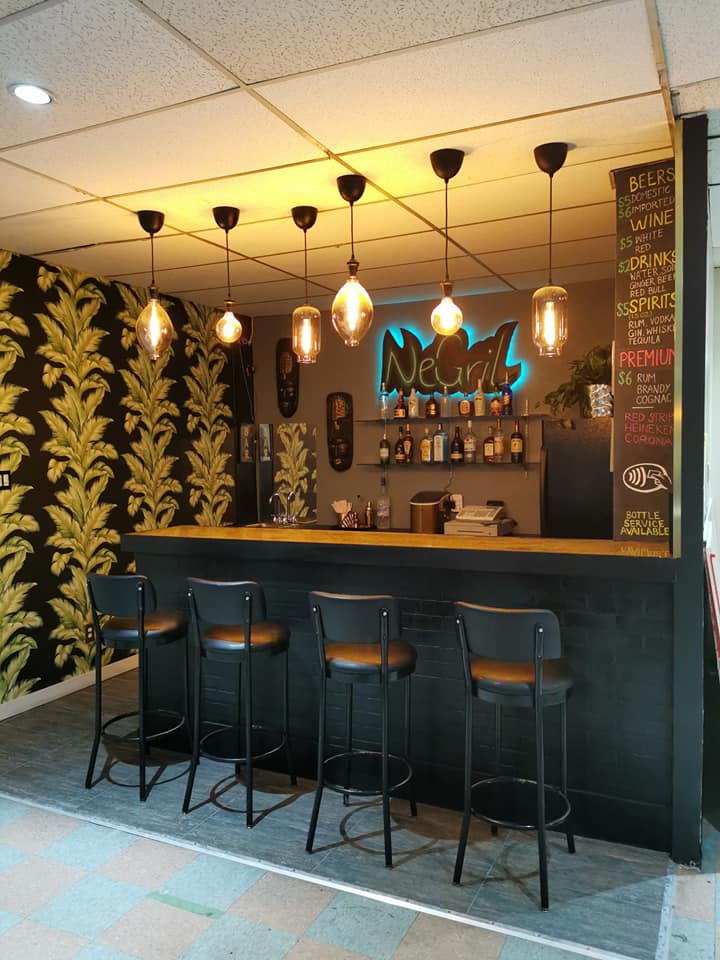 Cozy cocktail bar with stools and neon